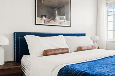 a bedroom with a white bed with a blue headboard at Bright & Modern Retreat - King Beds - Sloans Lake in Denver