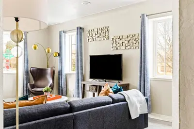 a living room with a blue couch and a tv at Stylish City Retreat - King Beds - Walk to Sloans Lake in Denver