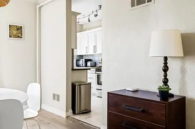 a living room with a table with a lamp on a dresser at Stylish City Retreat - King Beds - Walk to Sloans Lake in Denver