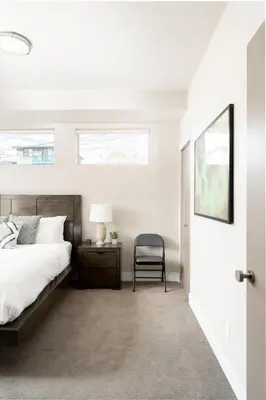 a bedroom with a bed and a chair next to a door at Center of LoHi - Roof Deck - Walk Everywhere in Denver