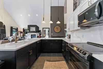 a kitchen with black cabinets and a clock on the wall at Arap Ldg 8130 in Keystone