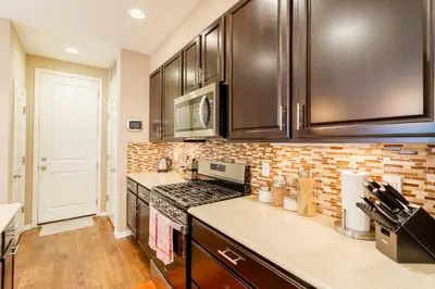 a kitchen with stainless steel appliances and a brick wall at Spacious Family Friendly Townhome in Central Park in Denver