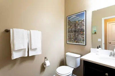 a bathroom with a toilet and a sink with towels at Spacious Family Friendly Townhome in Central Park in Denver