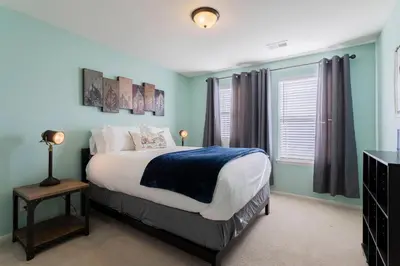 a bedroom with a bed with blue walls and a window at Spacious Family Friendly Townhome in Central Park in Denver