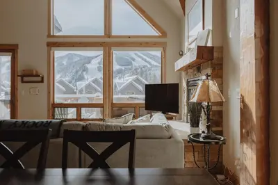 a living room with a couch and a large window at Hot Tub MTN Views - Free Shuttle - Central WP in Winter Park