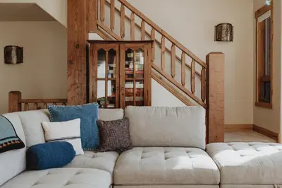 a living room with a couch and a staircase at Hot Tub MTN Views - Free Shuttle - Central WP in Winter Park
