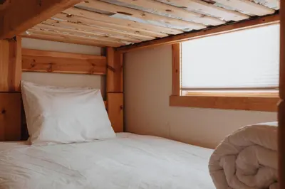 a bed with a white pillow in a room with a window at Hot Tub MTN Views - Free Shuttle - Central WP in Winter Park