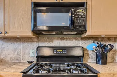 a microwave oven above a stove in a kitchen at 42 Burgundy 4Br 3,5Ba townhouse in Silverthorne
