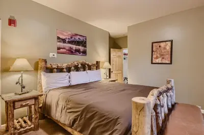 a bedroom with a large bed with a wooden headboard at 42 Burgundy 4Br 3,5Ba townhouse in Silverthorne