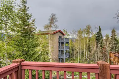 a red wooden fence with a building in the woods at 42 Burgundy 4Br 3,5Ba townhouse in Silverthorne