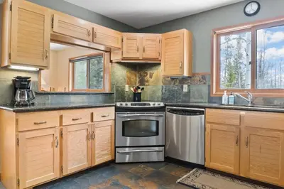 a kitchen with wooden cabinets and a stainless steel oven at 5BR Mountain Retreat with Hot Tub and Sauna in Silverthorne