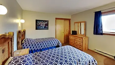 a bedroom with two beds and a dresser and a window at 135 Marina Place in Dillon