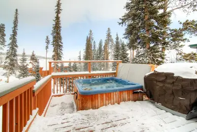 a hot tub on a deck in the snow at 2028 Ryan Gulch in Silverthorne