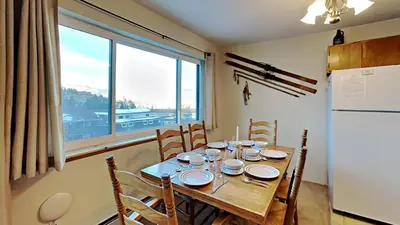 a dining room table with chairs and a large window at 205-F Buffalo Ridge in Silverthorne