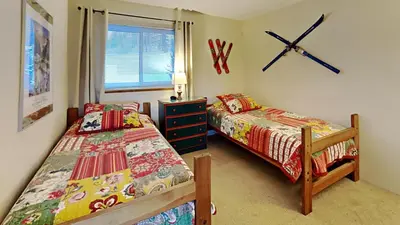a bedroom with two beds and a clock on the wall at 205-F Buffalo Ridge in Silverthorne