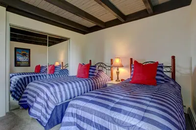 a bedroom with two beds with blue and red pillows at A203 Treehouse in Silverthorne