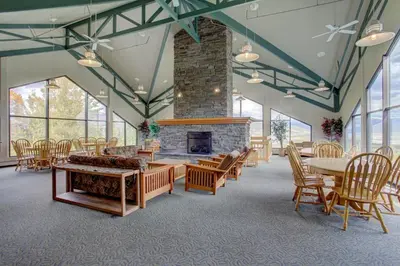 a large room with a fireplace and tables and chairs at A203 Treehouse in Silverthorne