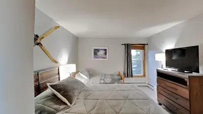 a bedroom with a bed and a flat screen tv at AA302 Buffalo Village in Silverthorne