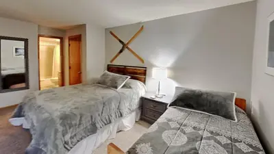 a bedroom with two beds and a mirror at AA302 Buffalo Village in Silverthorne