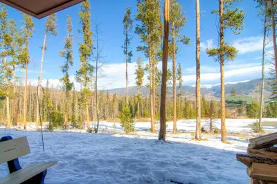 a porch with snow and trees and a bench at CC102 Buffalo Village in Silverthorne