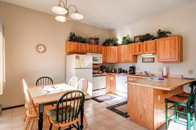 a kitchen with wooden cabinets and a table with chairs at B-101 Buffalo Ridge in Silverthorne