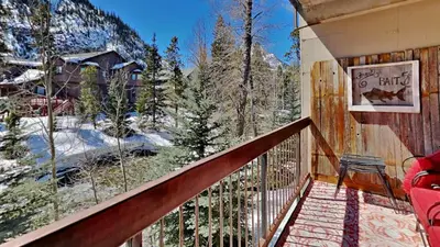 a balcony of a cabin with a view of the mountains at Ten Mile Island C220 in Frisco