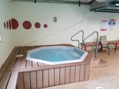 a hot tub on a wooden deck with two chairs at Ten Mile Island C220 in Frisco