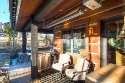 a porch with two chairs and a table and windows at Three Peaks Mountain Lodge in Silverthorne