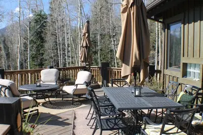 a patio with tables and chairs and umbrellas at Three Peaks Mountain Lodge in Silverthorne