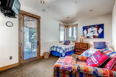 a bedroom with two beds and a tv and a couch at Three Peaks Mountain Lodge in Silverthorne