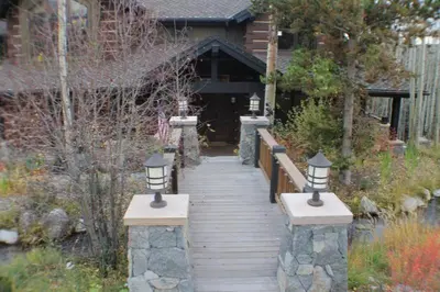 a wooden walkway leading to a house with three lights at Three Peaks Mountain Lodge in Silverthorne