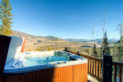 a hot tub on the deck of a house at Three Peaks Mountain Lodge in Silverthorne