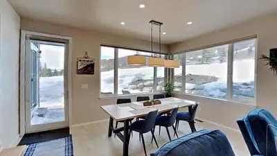 a dining room with a table and chairs and windows at 33 Corinthian Circle in Dillon
