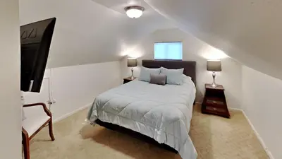 a white bedroom with a bed and a chair at Hummingbird House in Silverthorne