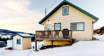 a house with a deck in the snow at Hummingbird House in Silverthorne
