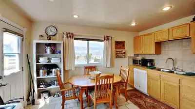 a kitchen with a table and chairs and a clock at Hummingbird House in Silverthorne