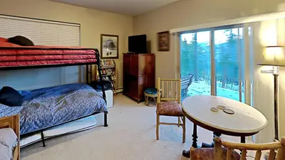 a bedroom with a bed and a table and a window at Miners Run 79 in Silverthorne