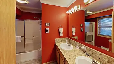 a bathroom with red walls and two sinks and a shower at Miners Run 79 in Silverthorne