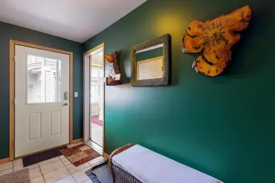 a room with a green wall with a bed and a mirror at Miners Run 79 in Silverthorne