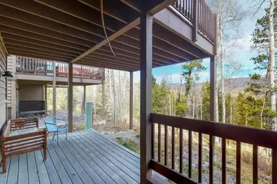 a deck with a bench and a table on it at Miners Run 79 in Silverthorne