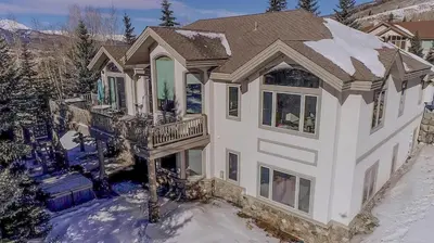 a large white house with a balcony in the snow at 36 James Court in Dillon