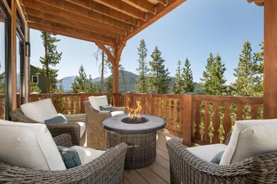 a patio with chairs and a fire pit on a deck at Ski Shores- The Chalet cabin in Grand Lake