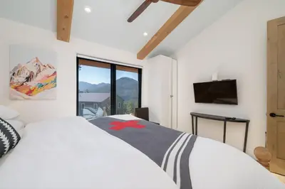 a bedroom with a white bed and a large window at Ski Shores- The Chalet cabin in Grand Lake