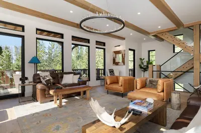 a living room filled with furniture and a chandelier at Ski Shores- The Chalet cabin in Grand Lake