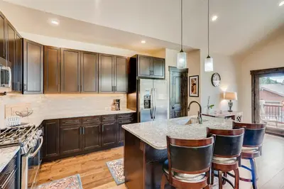 a kitchen with wooden cabinets and a kitchen island with bar stools at Alders 4 Bedroom Townhome In East Keystone in Keystone