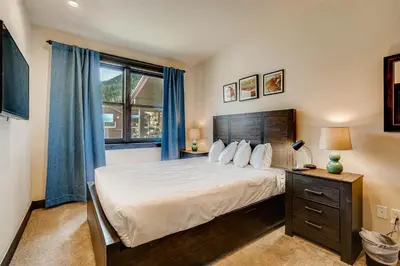 a bedroom with a large bed and a window at Alders 4 Bedroom Townhome In East Keystone in Keystone