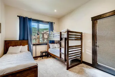 two bunk beds in a room with a window at Alders 4 Bedroom Townhome In East Keystone in Keystone