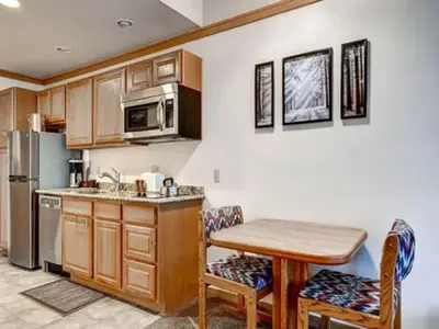 a kitchen with a table and a refrigerator and a table and chairs at Keystone Slopeside Studio Condo in Keystone