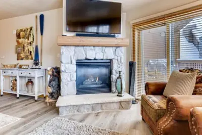a living room with a fireplace with a flat screen tv at River Run Village 3 Bedroom Condo in Keystone