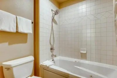 a bathroom with a tub and a toilet and a shower at River Run Village 3 Bedroom Condo in Keystone